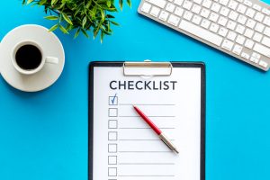 Checklist and pen on blue office background top view Checkliste: Wichtige Adressänderungen beim Umzug, Umzug Salzburg